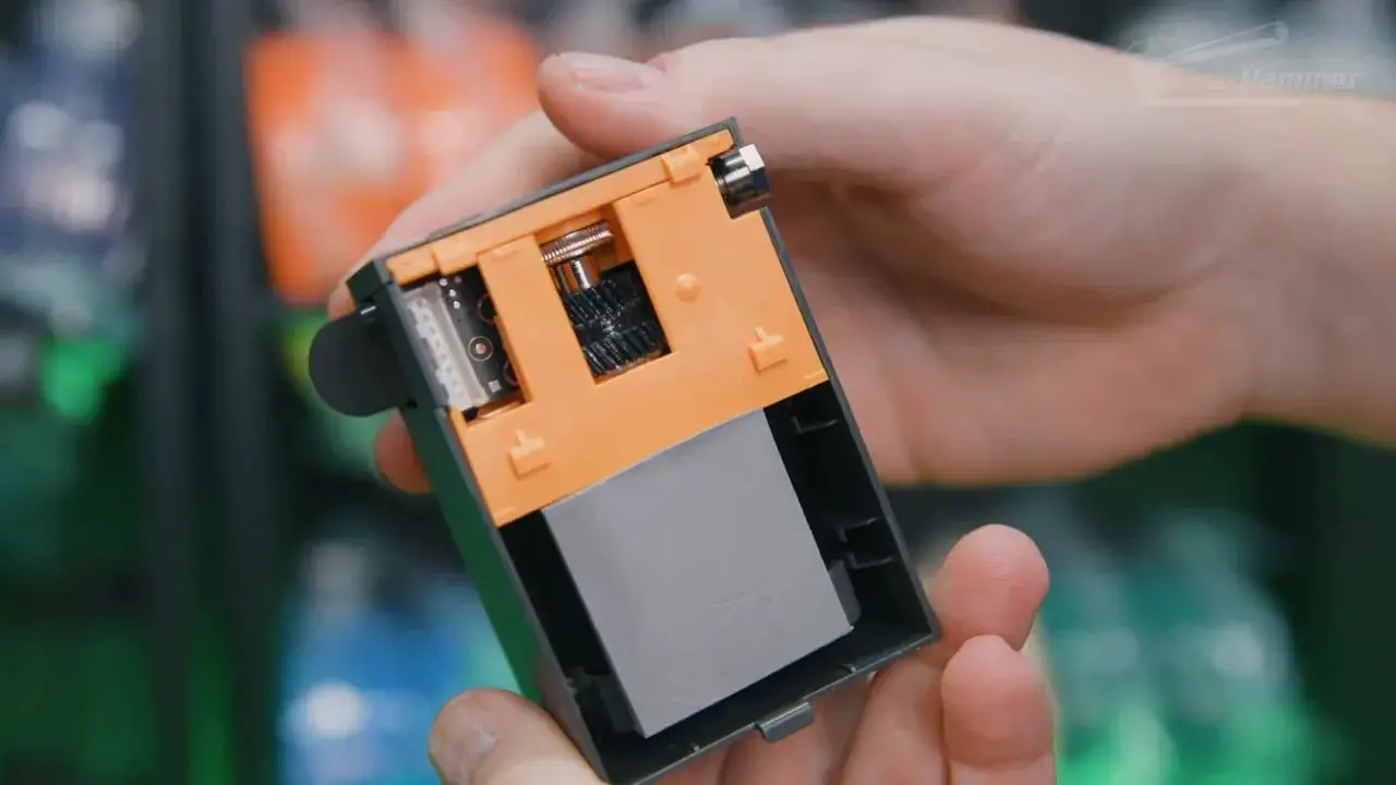 Close-up of the auxiliary extruder module from the rear of the Bambu X2D, showing the open housing and feed components