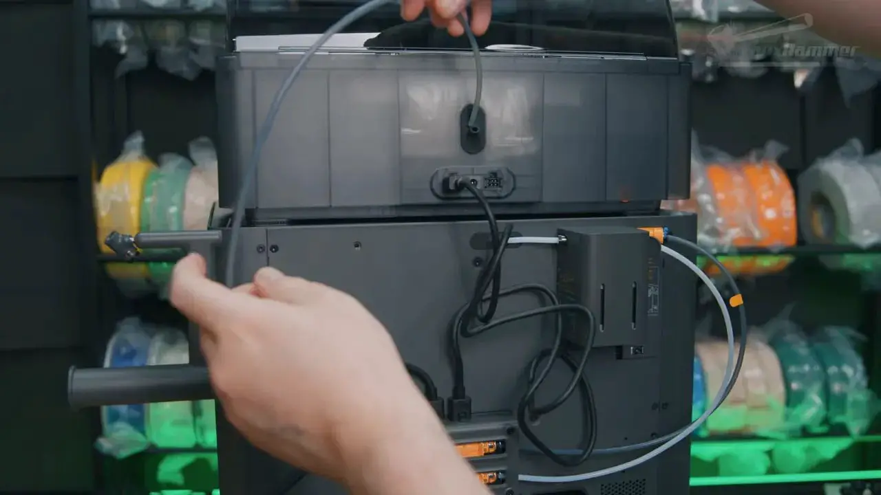 Hand adjusting rear connections and hoses on the Bambu X2D during setup