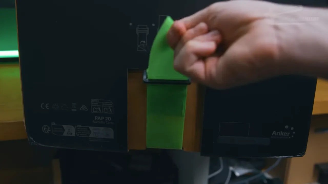 Hand removing a green insert from the EufyMake E1 box during unboxing