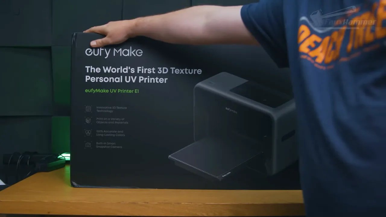 Hands holding the EufyMake E1 retail box showing the UV texture printer branding