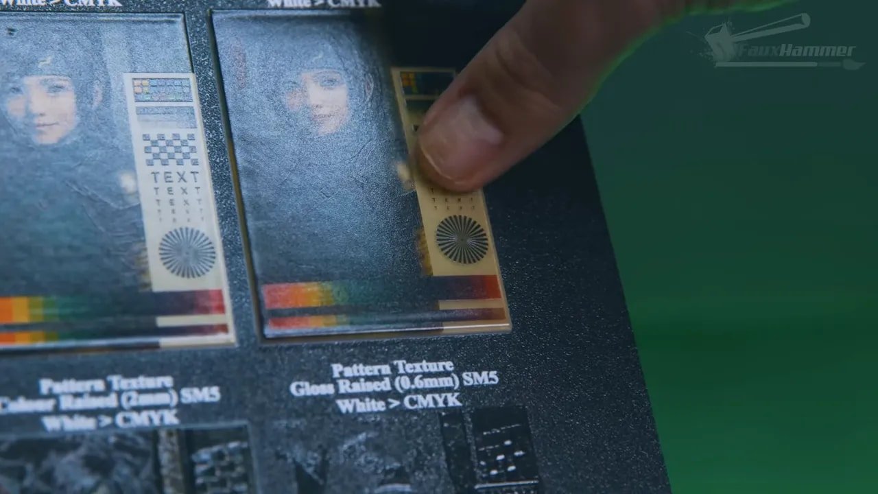 Hand holding a printed test panel with visible texture samples next to a second panel