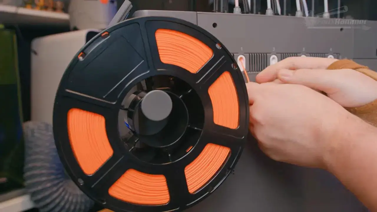 FlashForge Creator 5 filament reels being seated into the reel mount with a hand