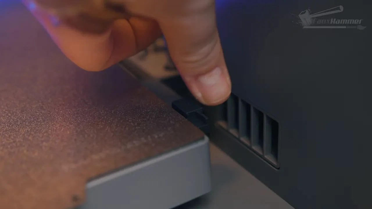 Hand inserting a filament-loading piece into the FlashForge Creator 5 side cassette area