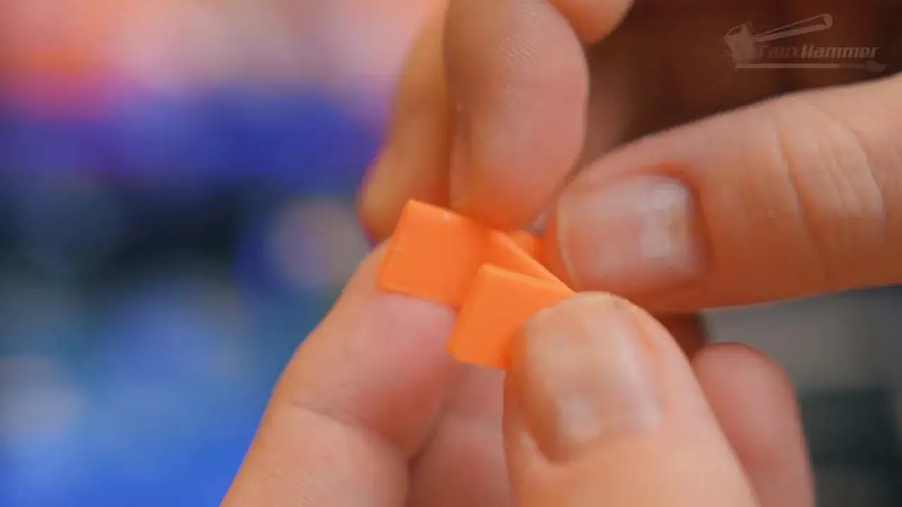 Close-up of an orange printed support interface piece held between fingers