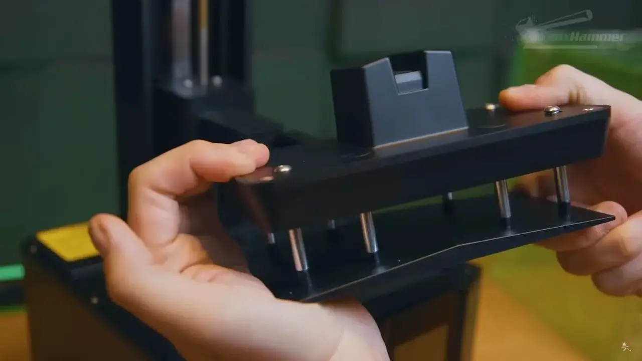 Hands adjusting or holding the Elegoo Mars 5 build plate