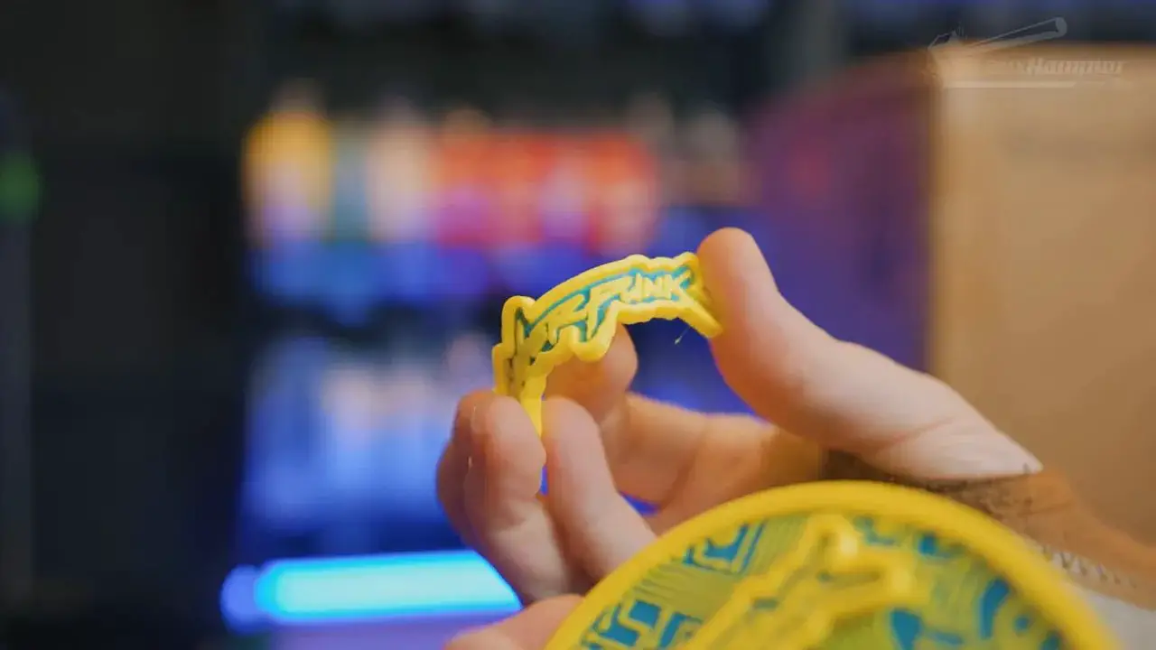 Hands holding a small 3D-printed TPU part in front of the FlashForge Creator 5