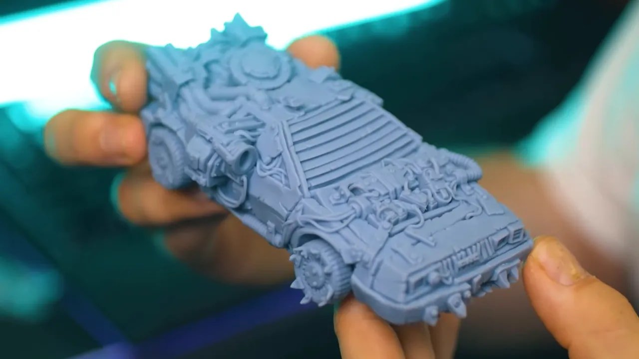 Resin miniature tank model held in hands with visible fine mechanical detail and smooth surface finish
