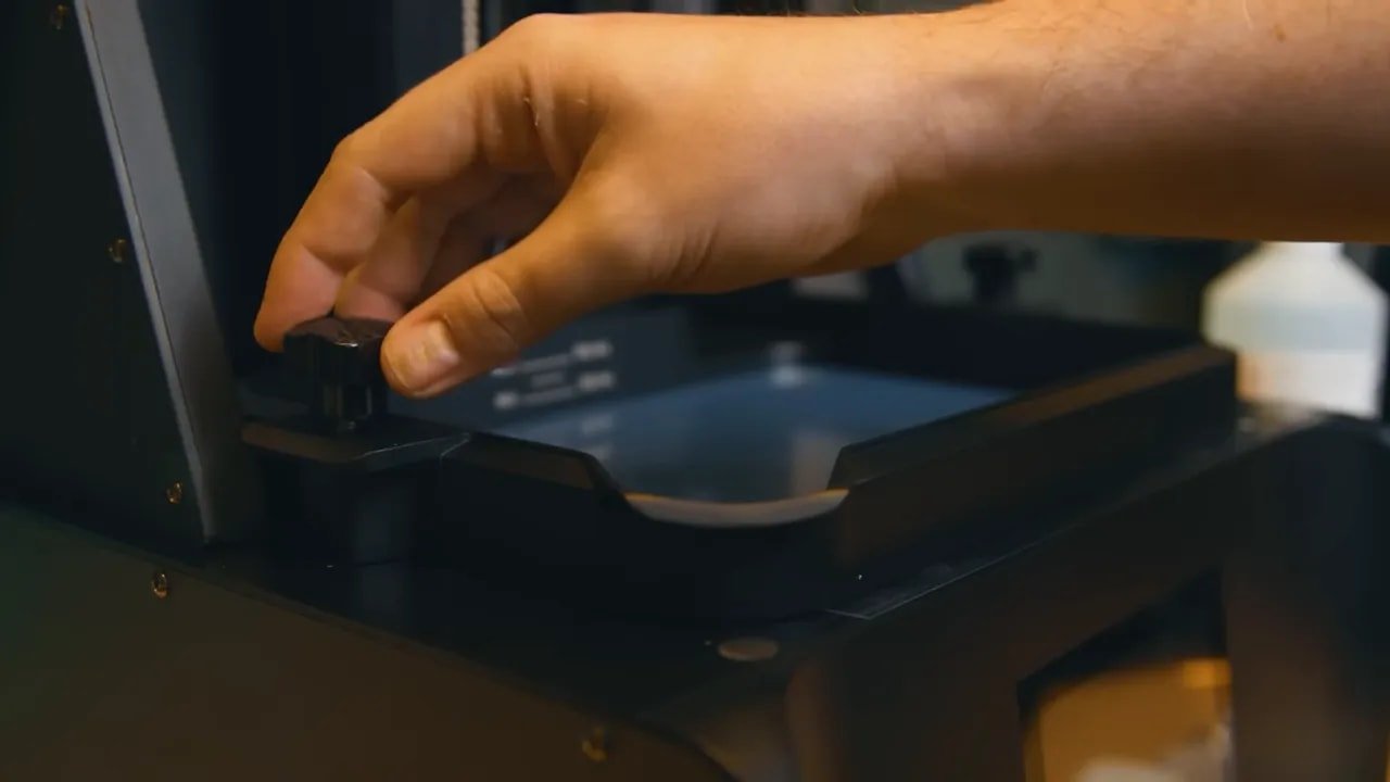 Hand lifting the lid of the HeyGears Reflex RS resin printer