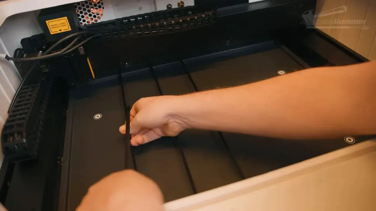 Hand placing a slat or support strip on the LaserPecker LX2 bed