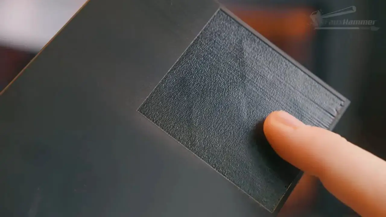 Close-up of a textured material sheet positioned for laser engraving