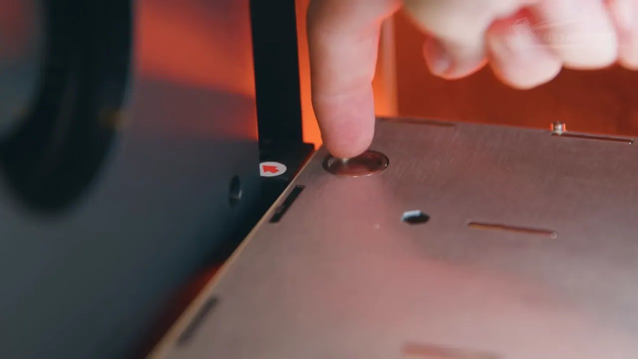 Hand adjusting or checking items near the Snapmaker U1 build surface during calibration
