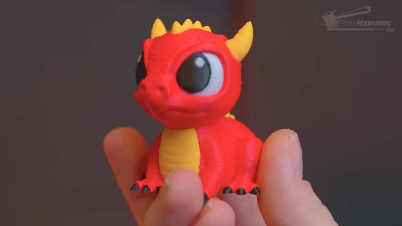 Red and yellow multi-colour printed dragon figurine being held up for display
