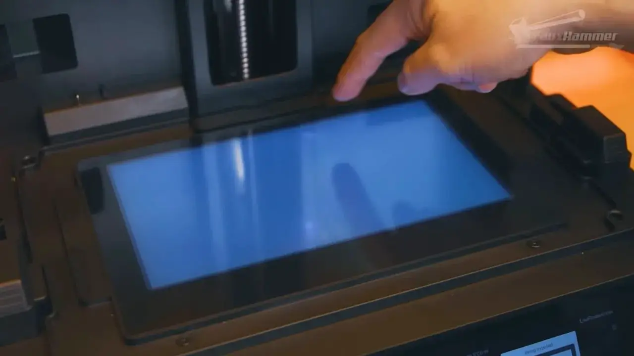 LCD screen on a Uniformation GK3 resin printer with finger pointing at the panel