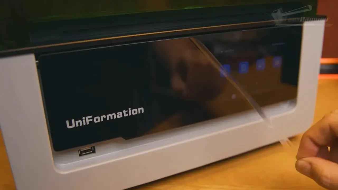 Hand pressing the recessed power area on the Uniformation GK3 with the rotating screen plate