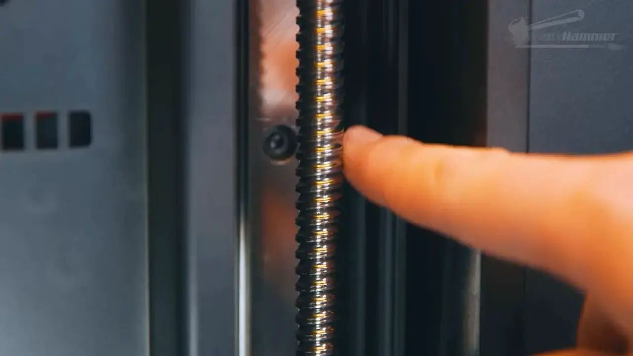 Uniformation GK3 Z-axis screw assembly close-up with pointer hand indicating the motion system