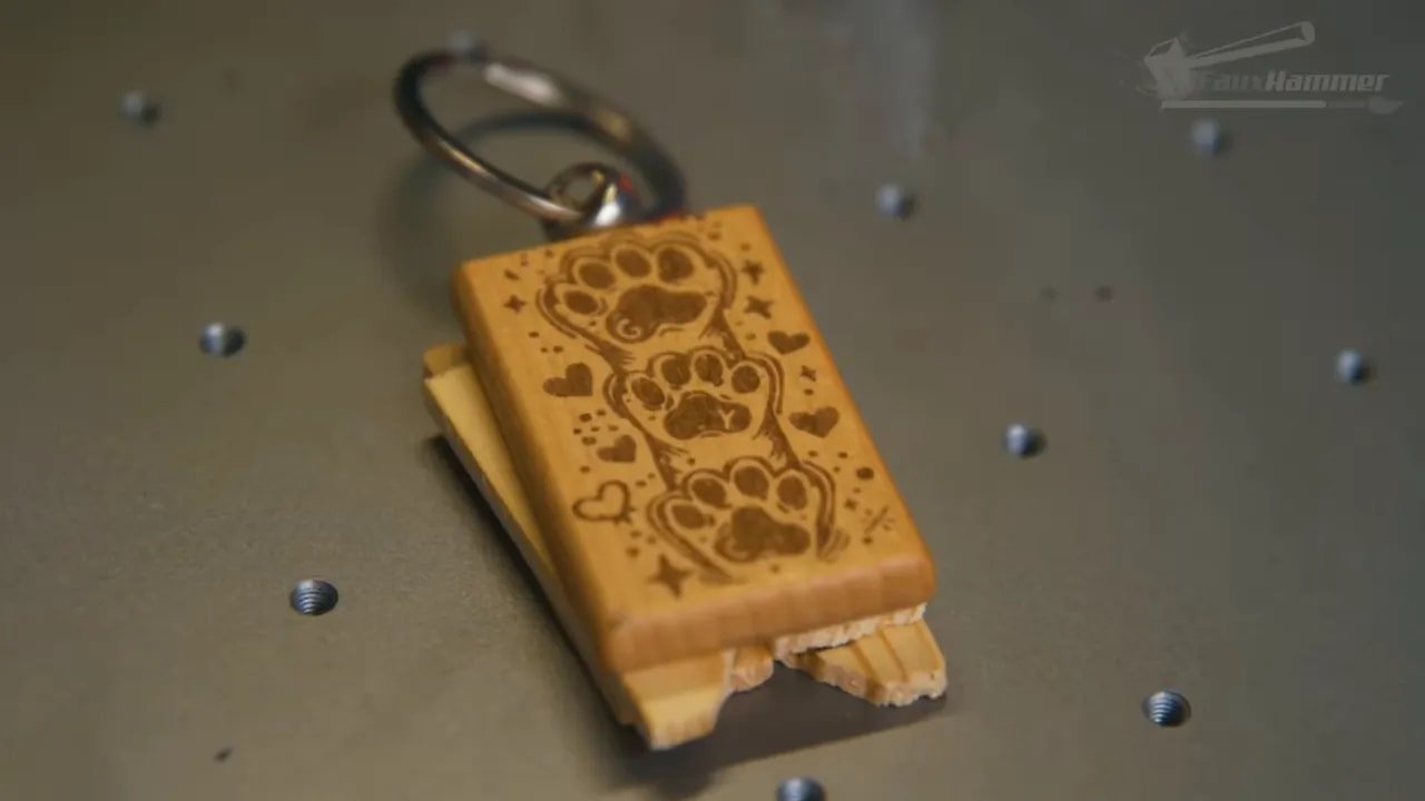 Small engraved wooden piece with a design pattern under a laser work setup